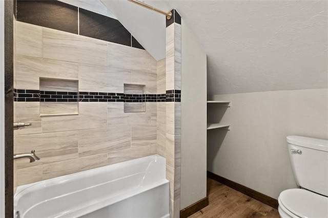 bathroom with vaulted ceiling, wood finished floors, toilet, baseboards, and a textured ceiling