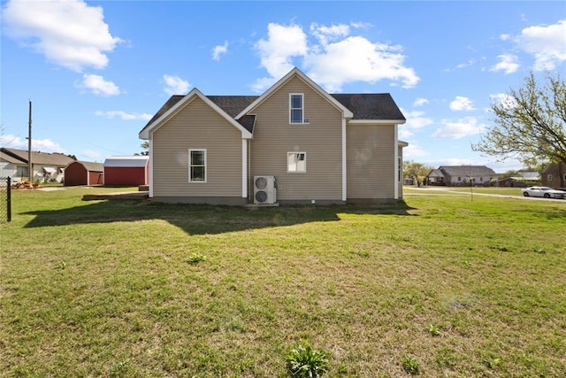 rear view of property featuring ac unit and a yard