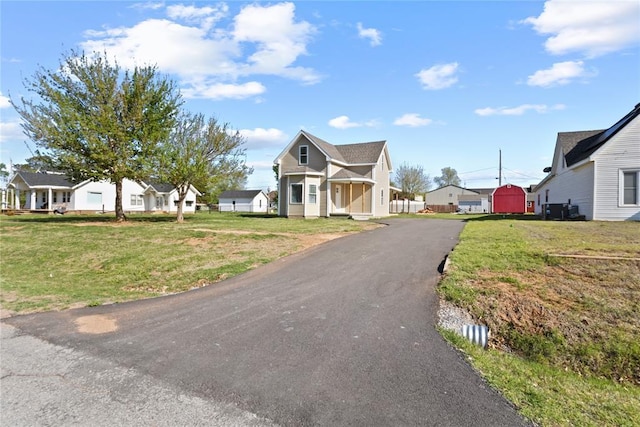 view of front of house with a front lawn, aphalt driveway, and a residential view