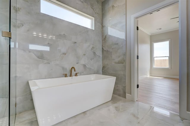 6508 NW 146th St, Oklahoma City, OK 73142 - full bath with a freestanding bath, ornamental molding, a healthy amount of sunlight, and tile walls
