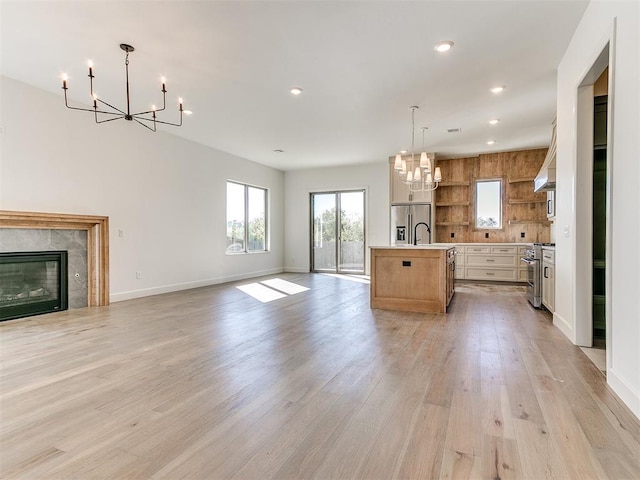 kitchen with a chandelier, stainless steel appliances, open shelves, light countertops, and open floor plan