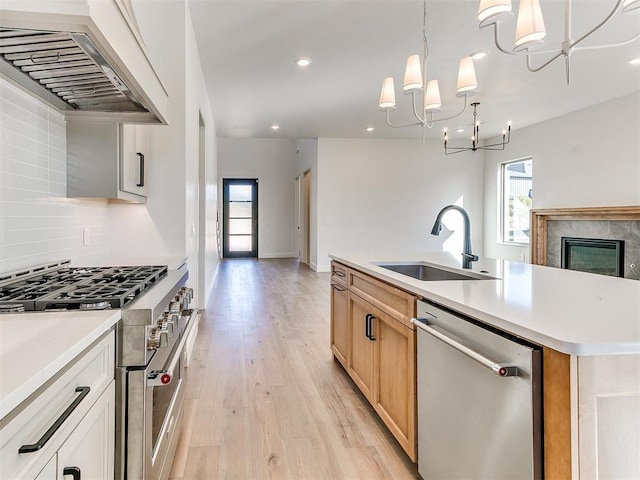 kitchen with decorative backsplash, custom range hood, a sink, a chandelier, and stainless steel appliances