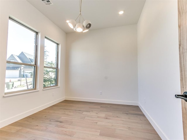 unfurnished room with recessed lighting, an inviting chandelier, light wood-style flooring, baseboards, and visible vents