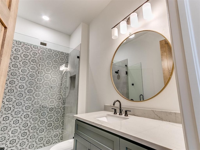 bathroom featuring toilet, a walk in shower, and vanity