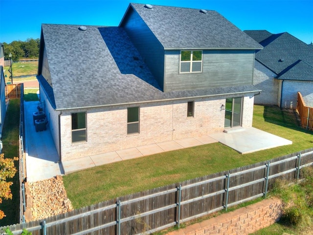 back of house featuring brick siding, roof with shingles, a fenced backyard, and a patio area