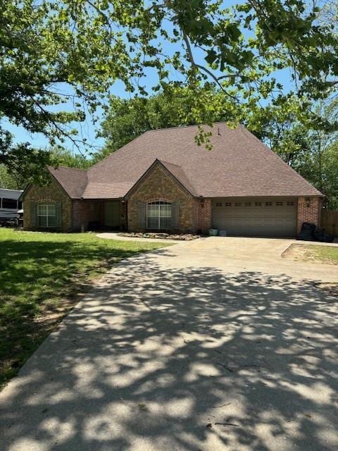 501 S 7th St, Okemah, OK 74859 - single story home with a garage, stone siding, a front lawn, and concrete driveway