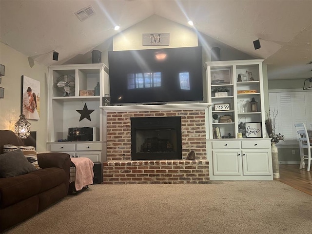 501 S 7th St, Okemah, OK 74859 - carpeted living room featuring vaulted ceiling, visible vents, and a fireplace