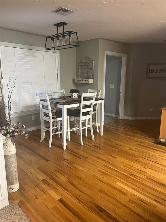 501 S 7th St, Okemah, OK 74859 - dining area with visible vents, baseboards, and wood finished floors