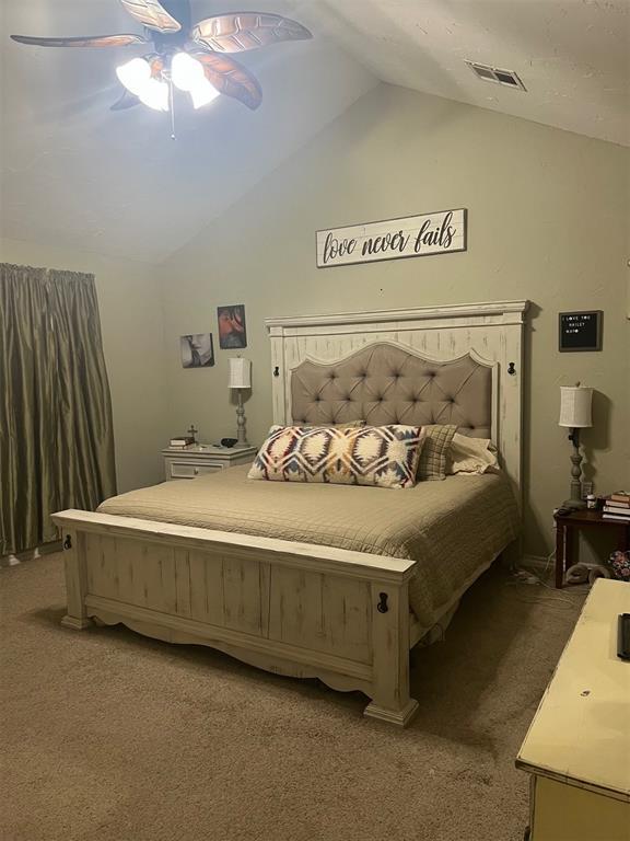 501 S 7th St, Okemah, OK 74859 - bedroom featuring vaulted ceiling, visible vents, carpet, and a ceiling fan