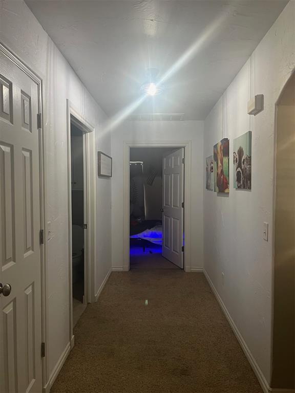501 S 7th St, Okemah, OK 74859 - corridor with carpet floors and baseboards