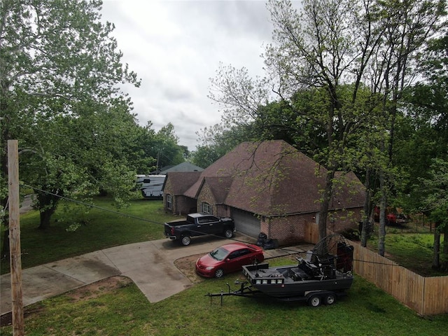 501 S 7th St, Okemah, OK 74859 - view of side of property with brick siding, fence, an attached garage, and a lawn