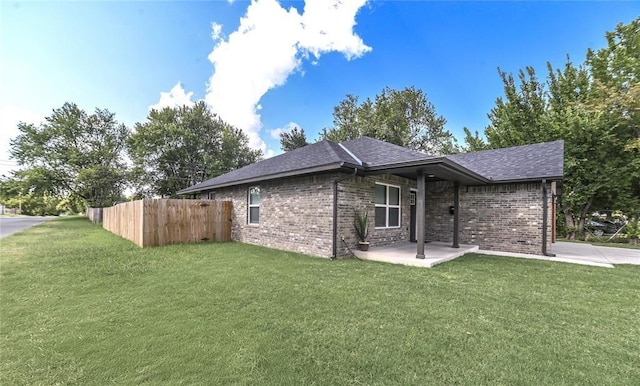 1717 Breckenridge Dr, Oklahoma City, OK 73115 - view of home's exterior featuring brick siding, a yard, a patio, and a shingled roof