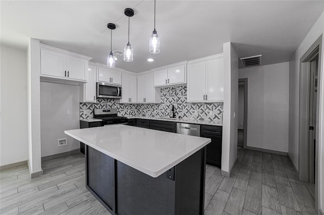 1717 Breckenridge Dr, Oklahoma City, OK 73115 - kitchen featuring light wood-type flooring, stainless steel appliances, visible vents, and white cabinetry