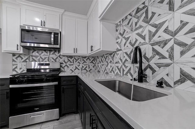 1717 Breckenridge Dr, Oklahoma City, OK 73115 - kitchen featuring white cabinets, stainless steel appliances, light countertops, and a sink