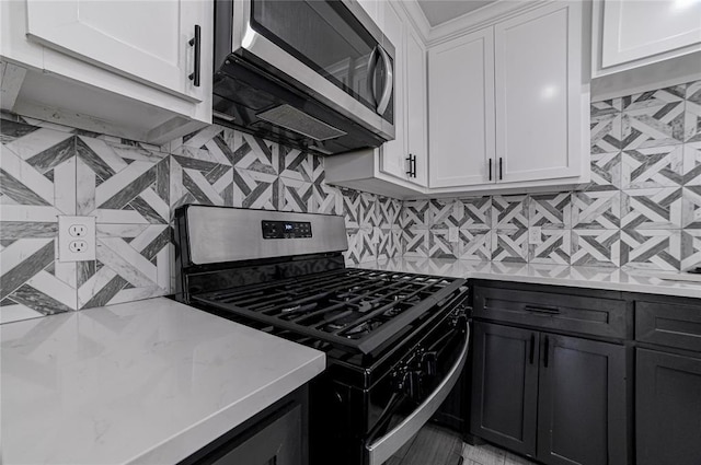 1717 Breckenridge Dr, Oklahoma City, OK 73115 - kitchen featuring stainless steel microwave, backsplash, range with gas stovetop, and white cabinets