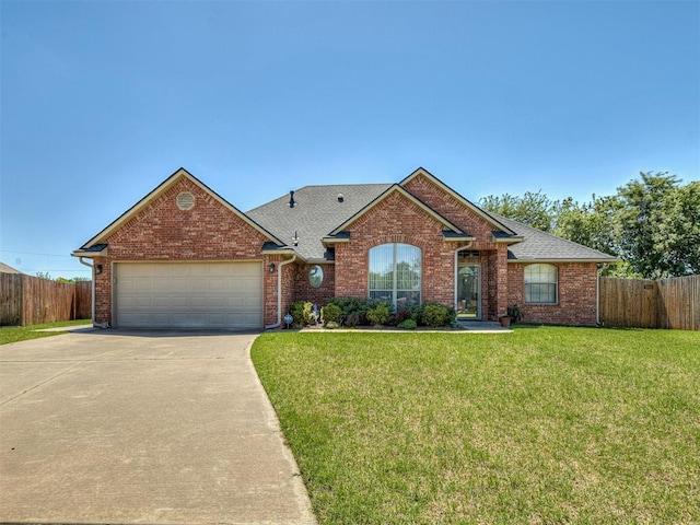 single story home with fence, a front lawn, driveway, and a garage