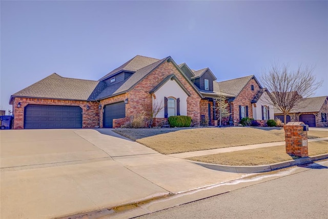 view of front of house with an attached garage, brick siding, and driveway
