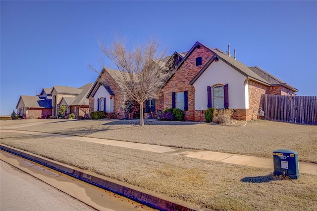 single story home with brick siding, fence, stone siding, and stucco siding