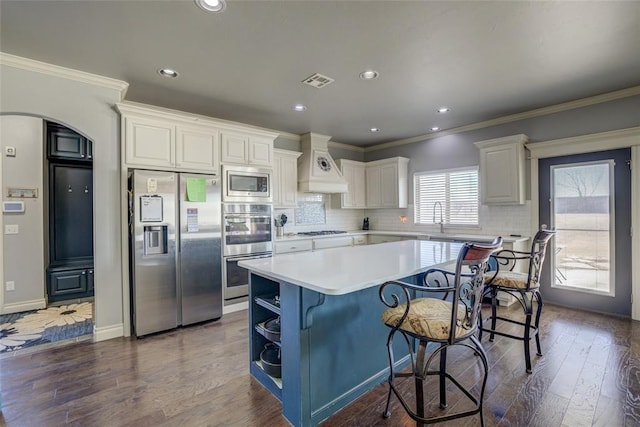 kitchen featuring custom exhaust hood, a center island, white cabinetry, dark wood finished floors, and appliances with stainless steel finishes