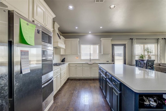 kitchen with blue cabinetry, stainless steel appliances, light countertops, and plenty of natural light