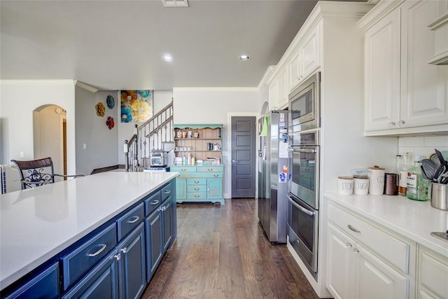 kitchen featuring blue cabinets, white cabinets, dark wood-style flooring, and ornamental molding