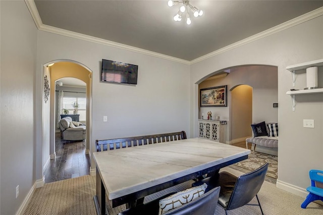 dining room with baseboards, arched walkways, and crown molding