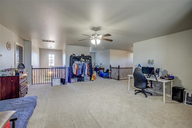 home office featuring carpet floors, visible vents, and ceiling fan