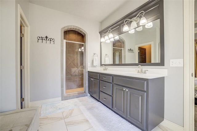 full bathroom featuring double vanity, a shower stall, marble finish floor, and a sink