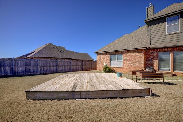 wooden deck featuring a fenced backyard and a yard