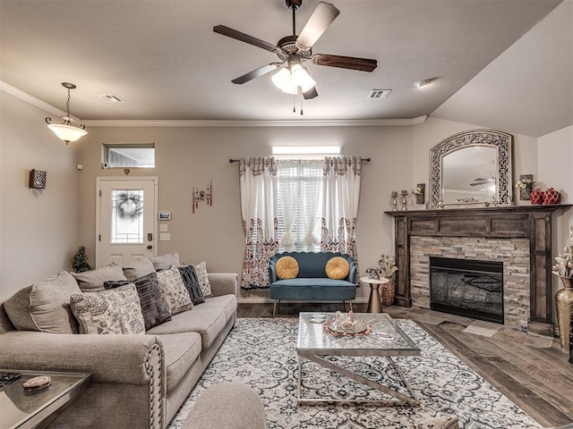 living area featuring a ceiling fan, a healthy amount of sunlight, wood finished floors, and visible vents