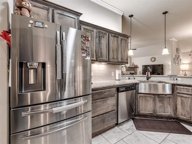 kitchen featuring light stone counters, light tile patterned floors, stainless steel appliances, and a sink