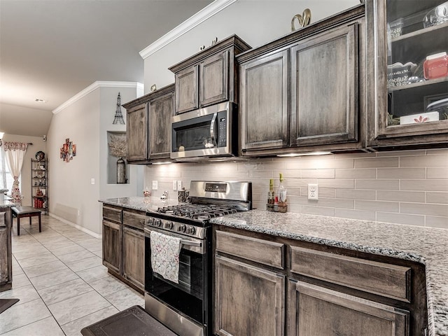 kitchen with crown molding, dark brown cabinets, backsplash, appliances with stainless steel finishes, and light stone countertops