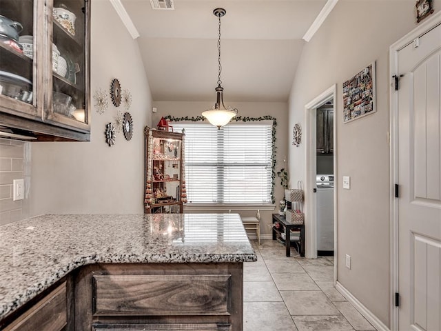 dining area with light tile patterned flooring, vaulted ceiling, visible vents, and baseboards