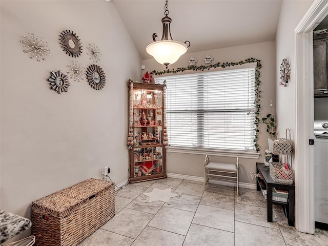interior space featuring vaulted ceiling, baseboards, and light tile patterned flooring