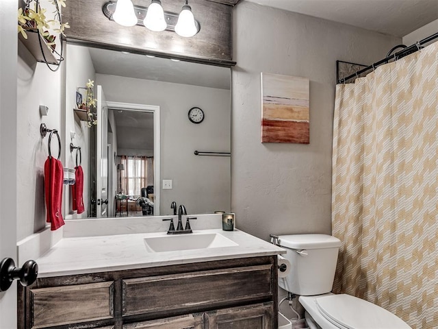 full bath with toilet, a textured wall, and vanity