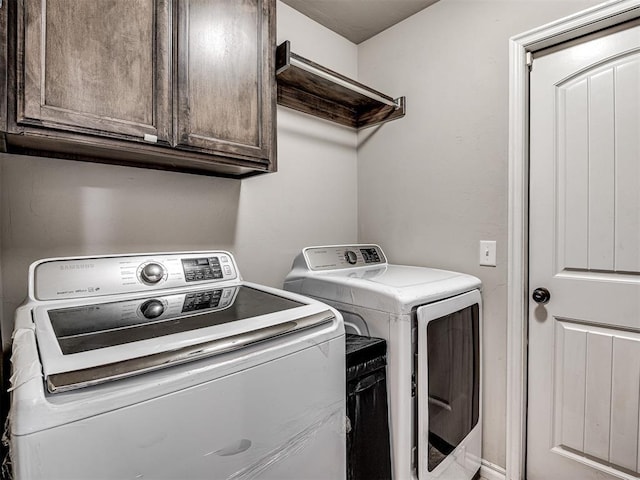 washroom featuring separate washer and dryer and cabinet space