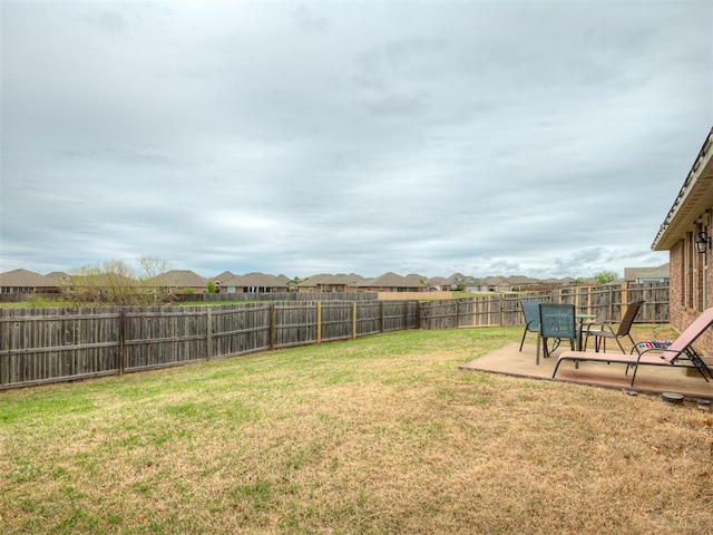 view of yard with a fenced backyard, a residential view, and a patio