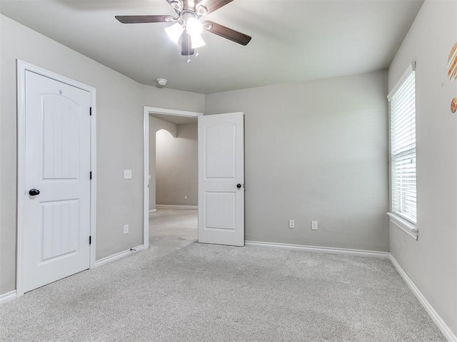 18232 Scarborough Dr, Edmond, OK 73012 - unfurnished bedroom with light colored carpet, a ceiling fan, and arched walkways
