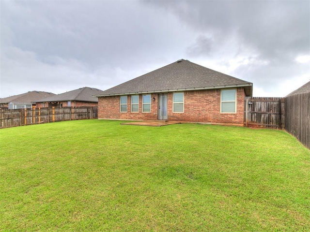 18232 Scarborough Dr, Edmond, OK 73012 - rear view of property featuring a fenced backyard, brick siding, and a shingled roof