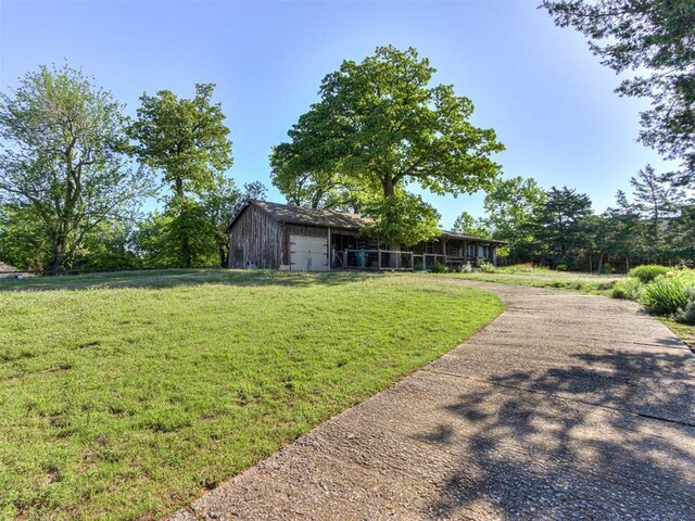view of yard featuring driveway and a garage