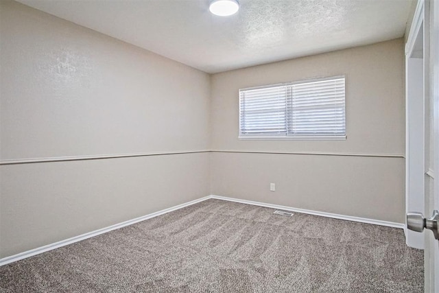unfurnished room featuring carpet floors, visible vents, and baseboards