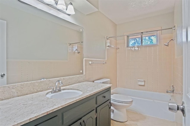full bath featuring tile patterned floors, toilet, vanity, tile walls, and shower / tub combination