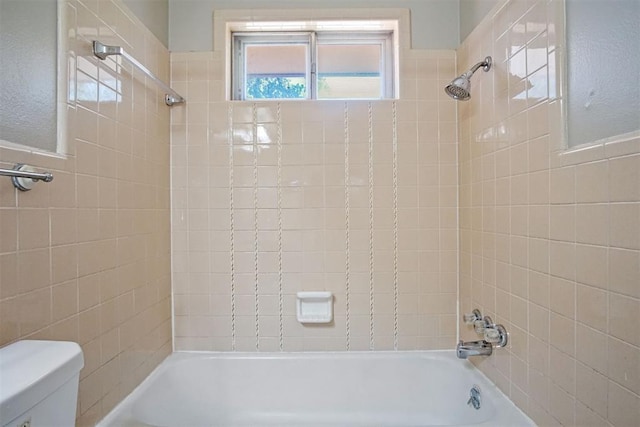 bathroom with toilet, tile walls, and shower / bathing tub combination