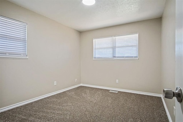 carpeted empty room with visible vents and baseboards
