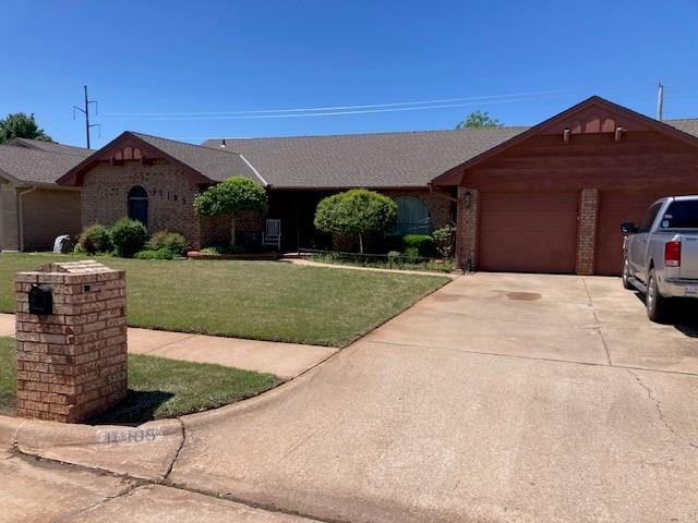 ranch-style house with a garage, brick siding, driveway, and a front yard