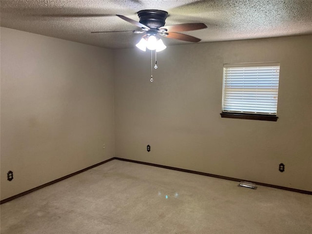 unfurnished room featuring ceiling fan, light carpet, baseboards, and a textured ceiling