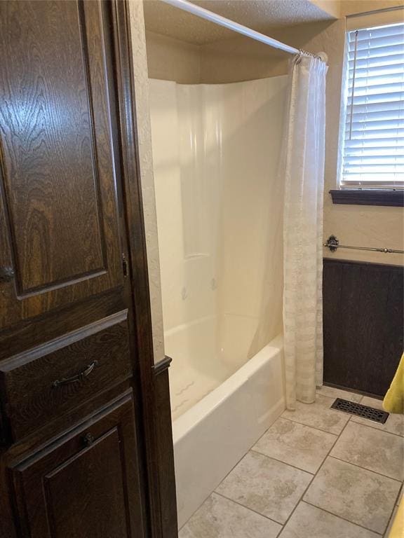 full bathroom featuring tile patterned floors and shower / tub combo with curtain