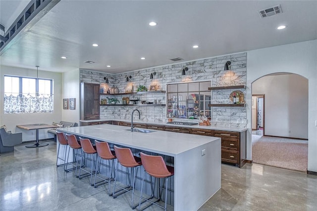 25478 Sooner Ave, Purcell, OK 73080 - kitchen with open shelves, arched walkways, a kitchen breakfast bar, light countertops, and a large island