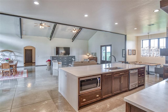 25478 Sooner Ave, Purcell, OK 73080 - kitchen featuring stainless steel appliances, light countertops, ceiling fan, an island with sink, and arched walkways