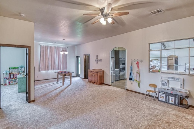25478 Sooner Ave, Purcell, OK 73080 - playroom with light carpet, a ceiling fan, arched walkways, and a chandelier